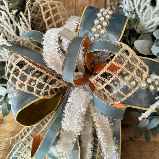 Decorative bow with ribbons and pearls on a textured surface