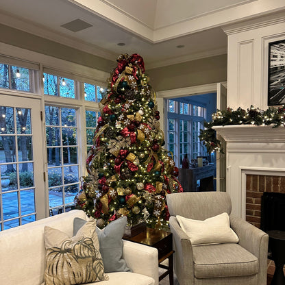 Living room with a decorated Christmas tree, sofa, and armchair.