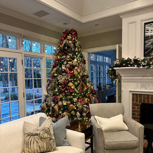 Living room with a decorated Christmas tree, sofa, and armchair.
