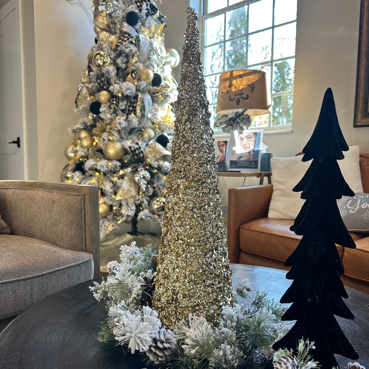 Decorative Christmas trees in a living room setting with a couch and lamp.