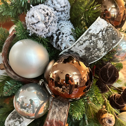 Decorative Christmas wreath with ornaments and ribbons on a green background