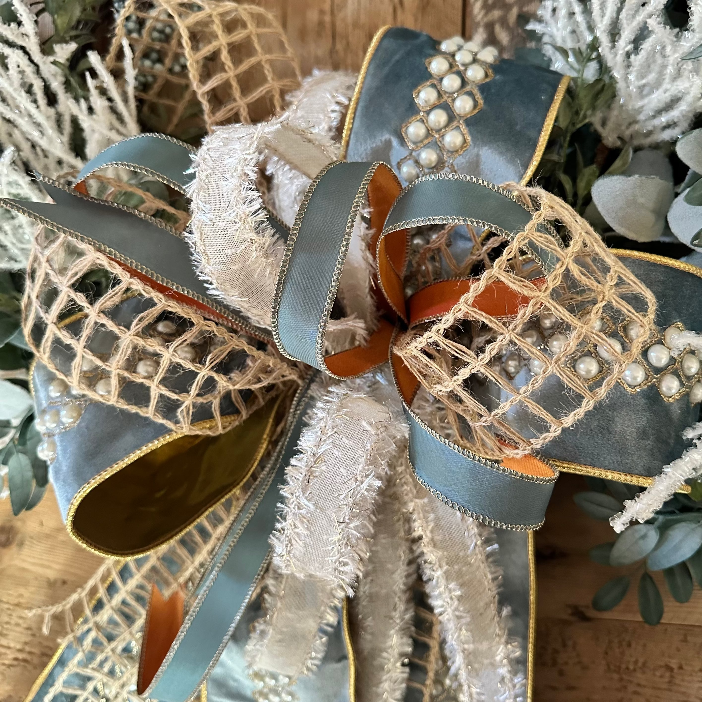 Decorative bow with ribbons and pearls on a textured surface