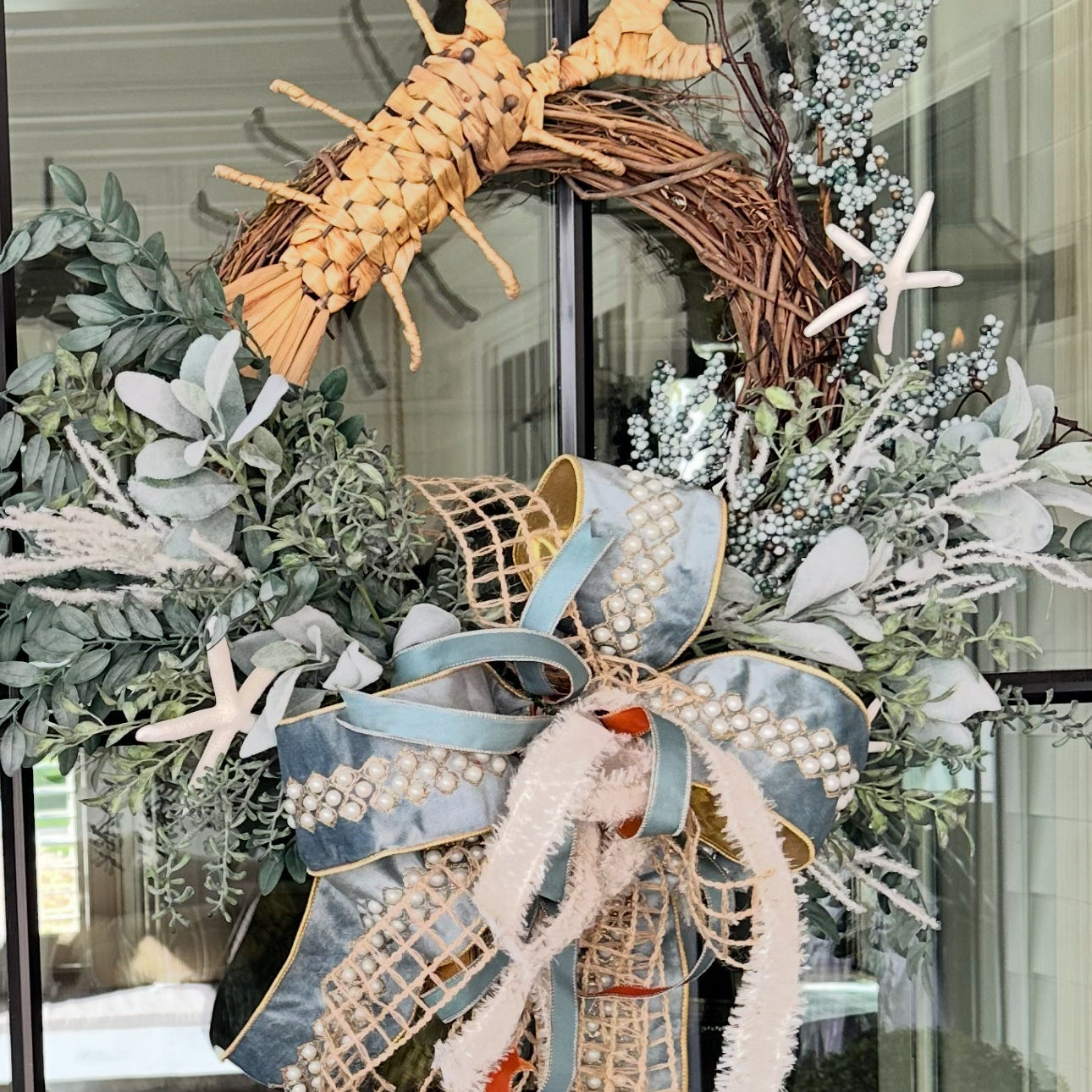 Decorative wreath with a lobster and starfish on a glass door